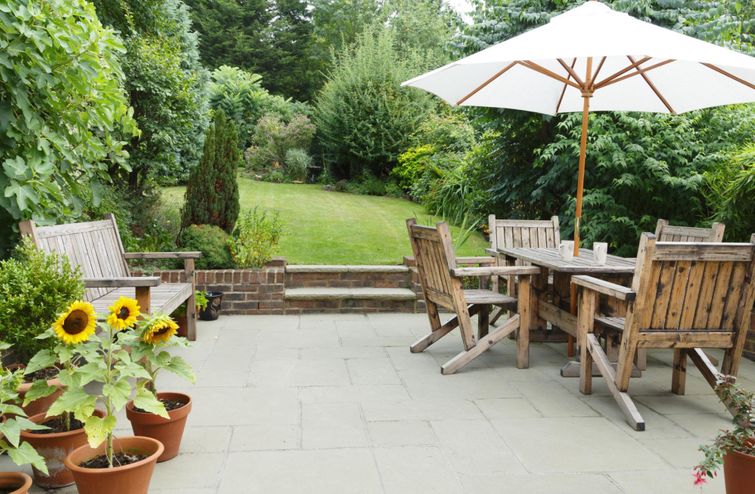 A patio featuring a table, chairs, and umbrella - all essentials for constructing a patio.