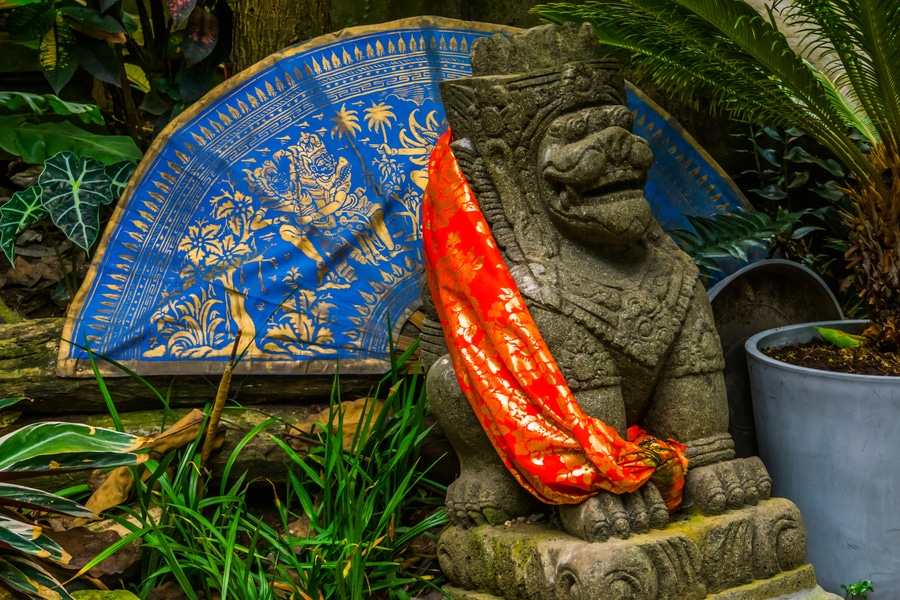 A feng shui dog statue with a red scarf around its neck.