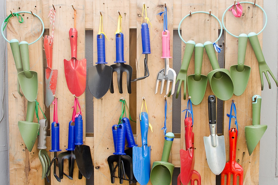 Gardening utensils displayed on a storage rack.