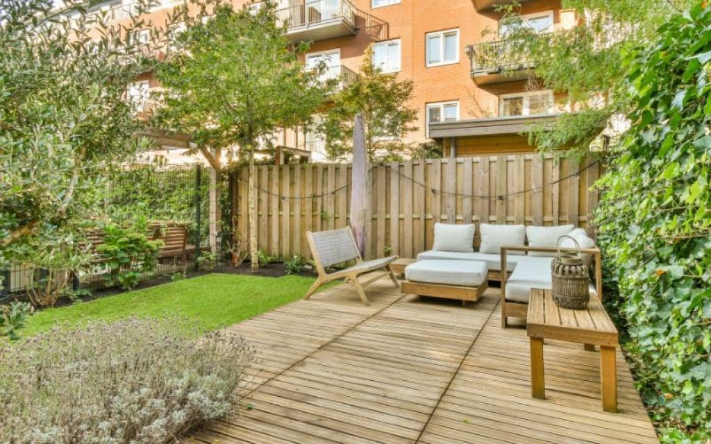 a backyard with a wooden deck with furniture