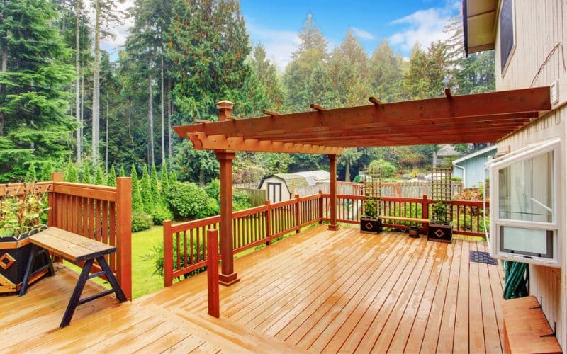 a wooden deck with a picnic table and bench.