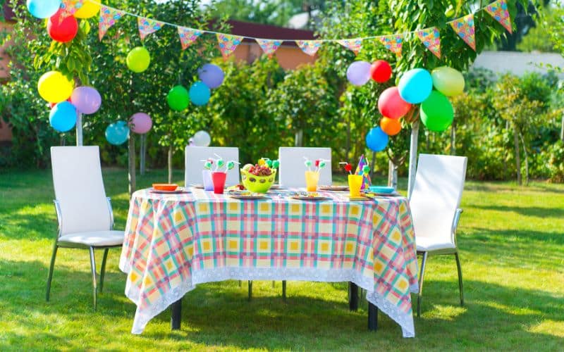 a table set up for a birthday party in a garden.