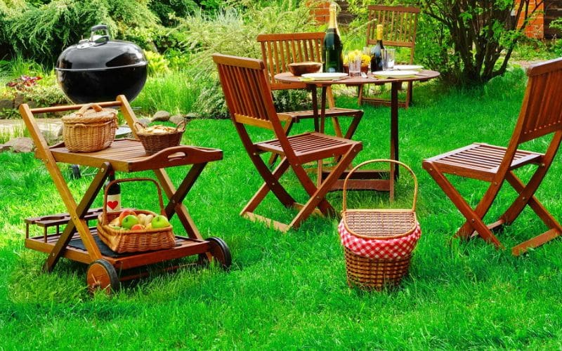 a wooden table and chairs in a grassy area.