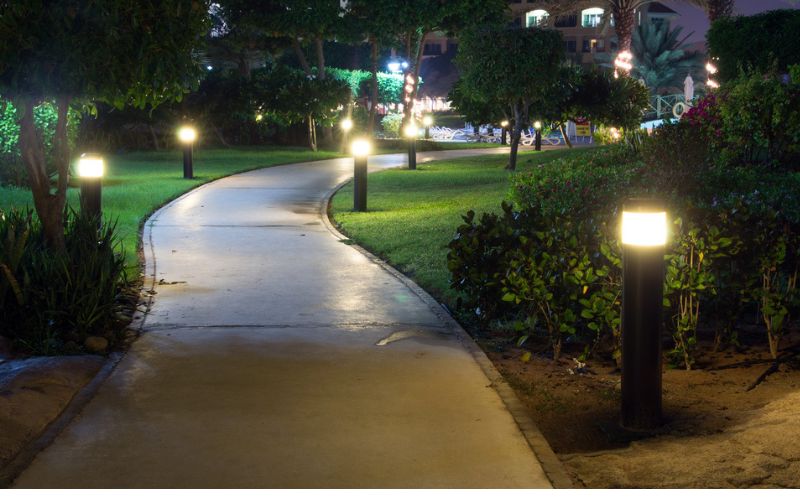 a pathway lit up at night in a garden