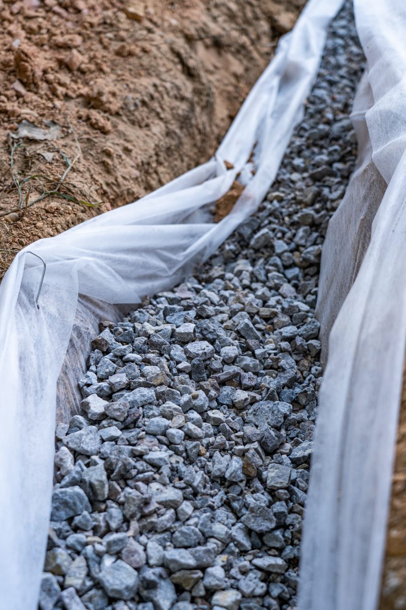 A white tarp covering a trench in the ground.