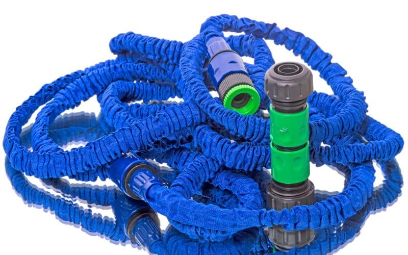 A blue and green expandable hose with a green nozzle.