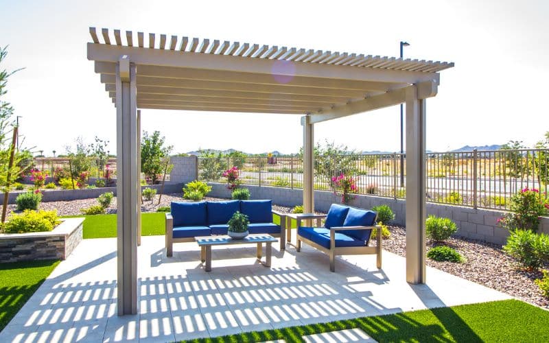 A patio with blue furniture and a pergola.