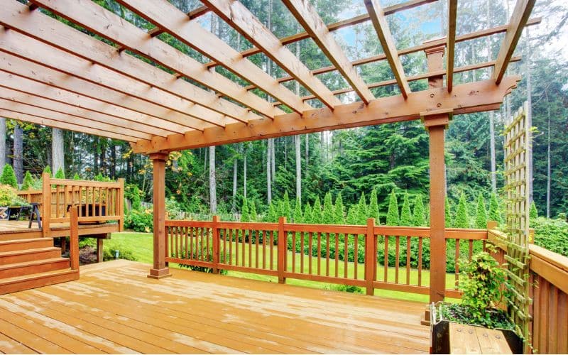 A wooden deck with a wooden pergola.