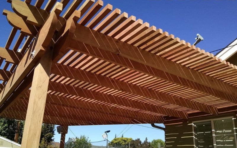 A wooden pergola with slats on it.