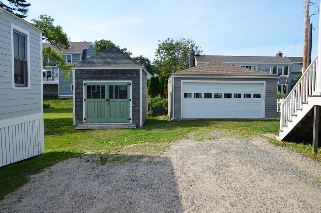 Two garages and a driveway in front of a house.