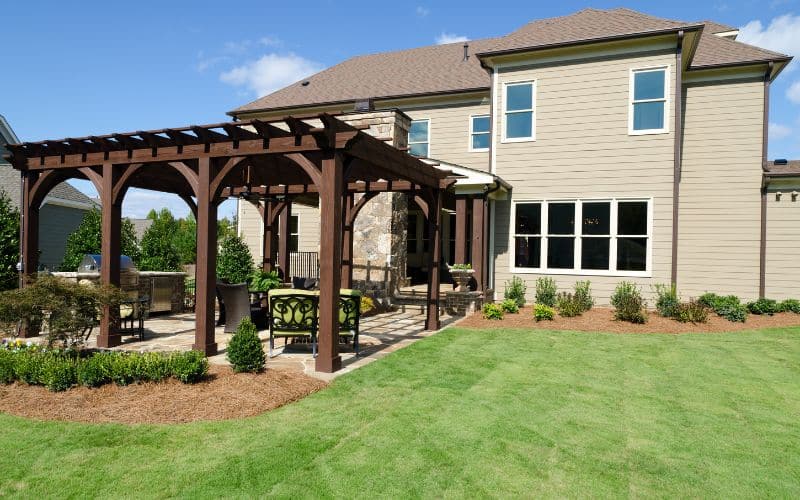A backyard with a pergola and patio.