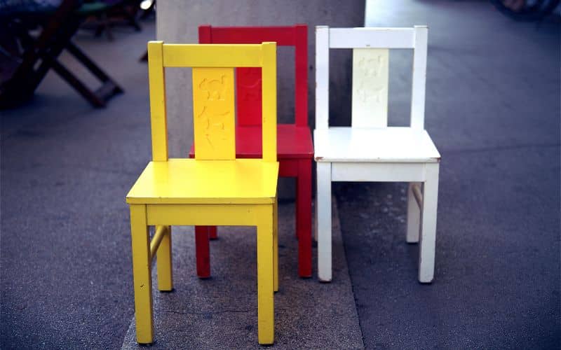 Three colorful kids chairs sitting next to each other.
