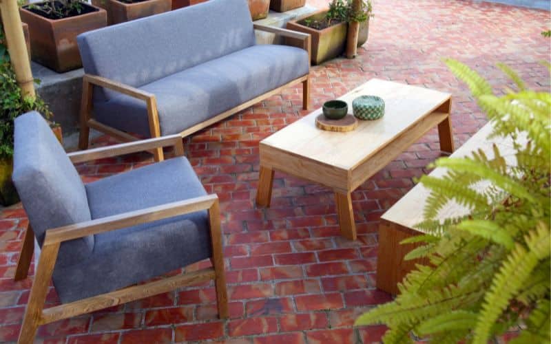 A set of modern outdoor furniture in a brick patio.