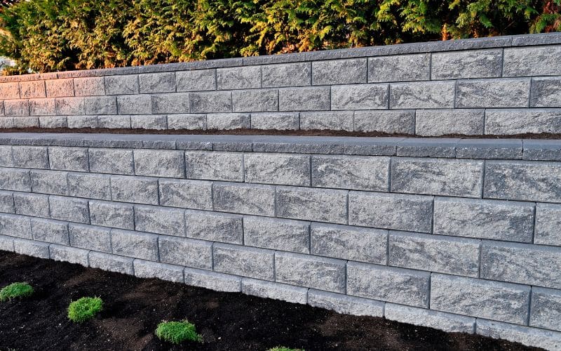A concrete block retaining wall in a garden.
