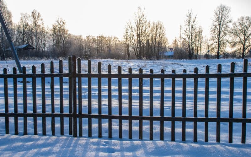 A snow fence installed in a garden to prevent snow drifts