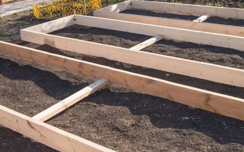 Constructing a raised garden bed with layers of gravel, compost, and topsoil